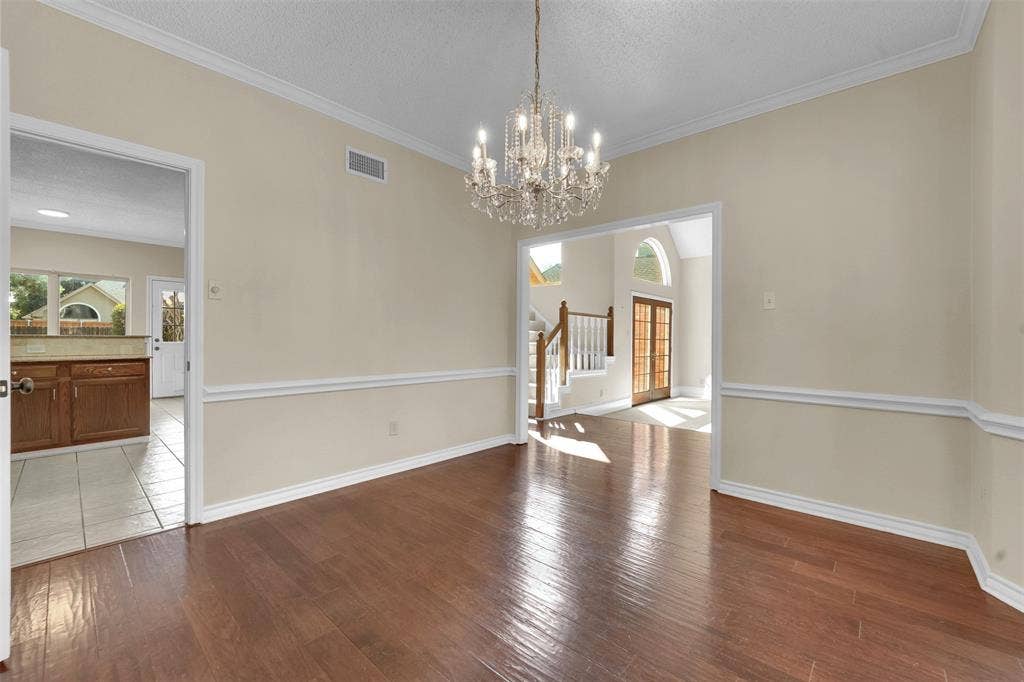 1920 Keystone Drive, Plano, TX 75075 Hardwood-finish flooring, crown molding, chair rail molding, and a crystal chandelier