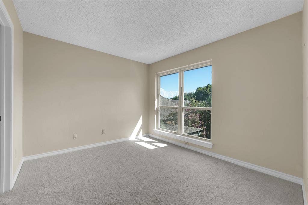 1920 Keystone Drive, Plano, TX 75075 Neutral wall finishes, textured ceiling, light gray carpeting, and a multi-pane window