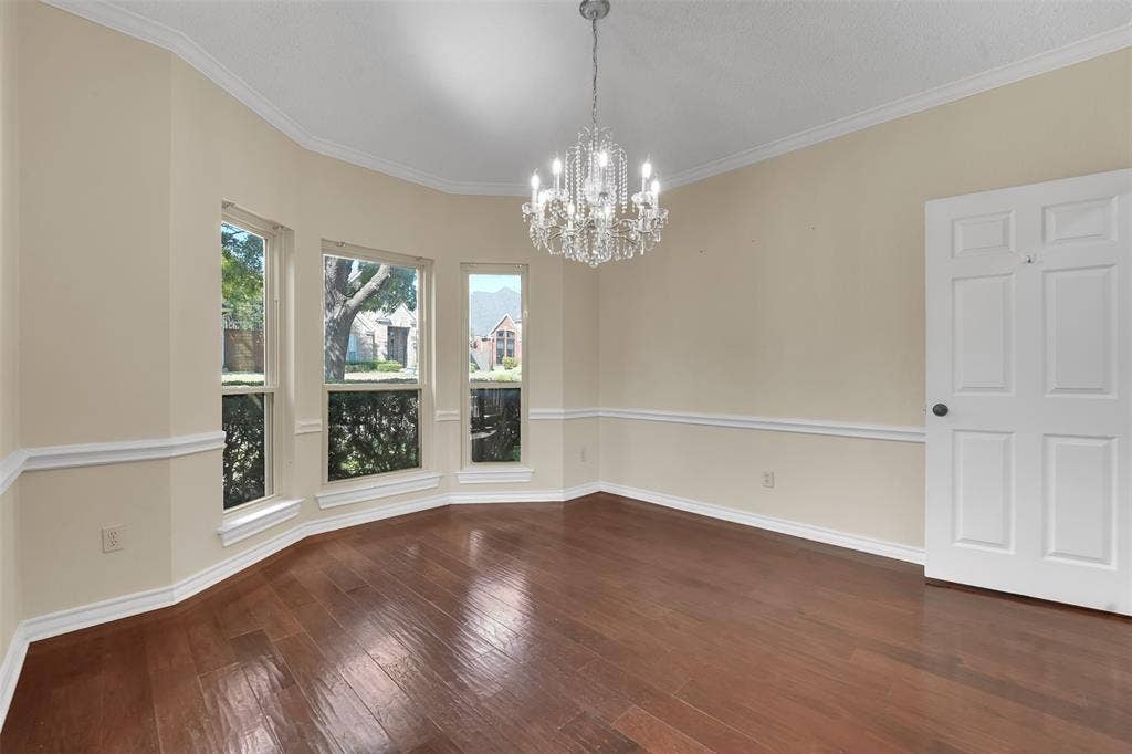 1920 Keystone Drive, Plano, TX 75075 Hardwood flooring, bay window configuration, crown molding, chair rail molding, and a crystal chandelier