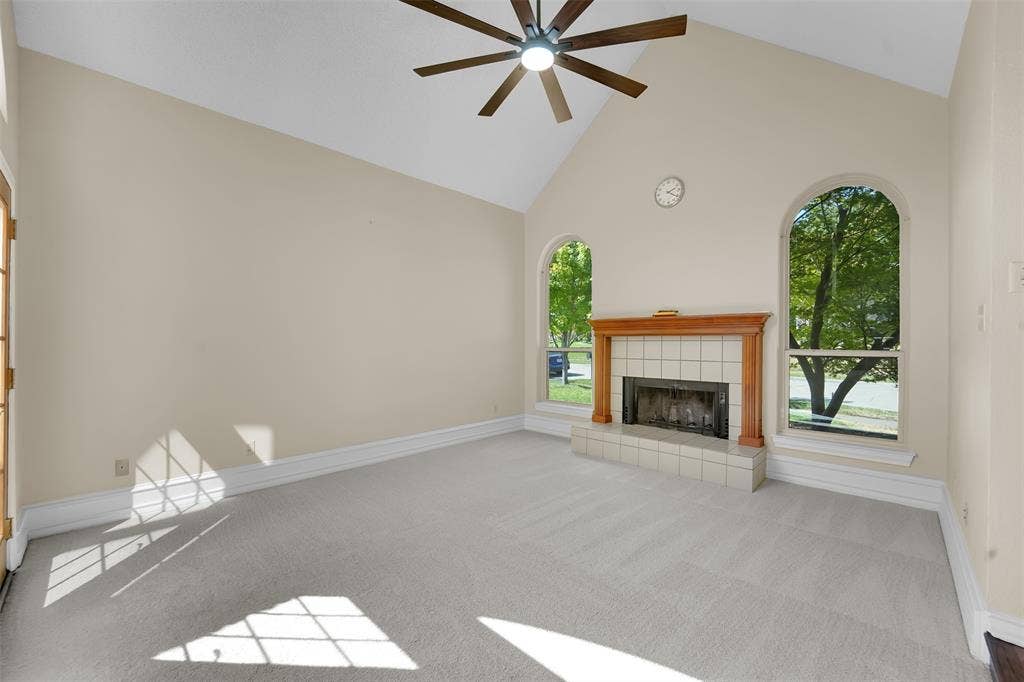 1920 Keystone Drive, Plano, TX 75075 Vaulted ceiling, ceiling fan, wood-mantled fireplace, tiled hearth, and arched windows