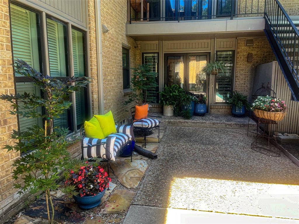 10719 Villager Road, #A, Dallas, TX 75230 Expansive patio featuring exposed aggregate concrete, brick exterior, and a built-in outdoor staircase