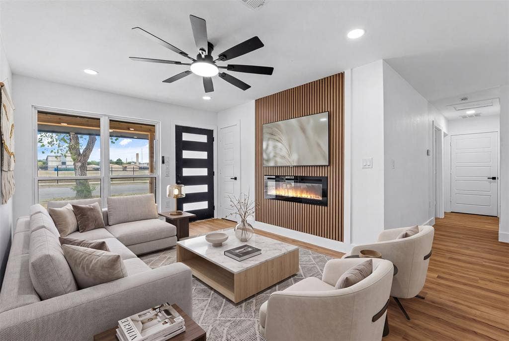565 alcorn Avenue, Dallas, TX 75217 Recessed lighting, wood-finish flooring, a modern ceiling fan, an accent wall with an electric fireplace, and large windows