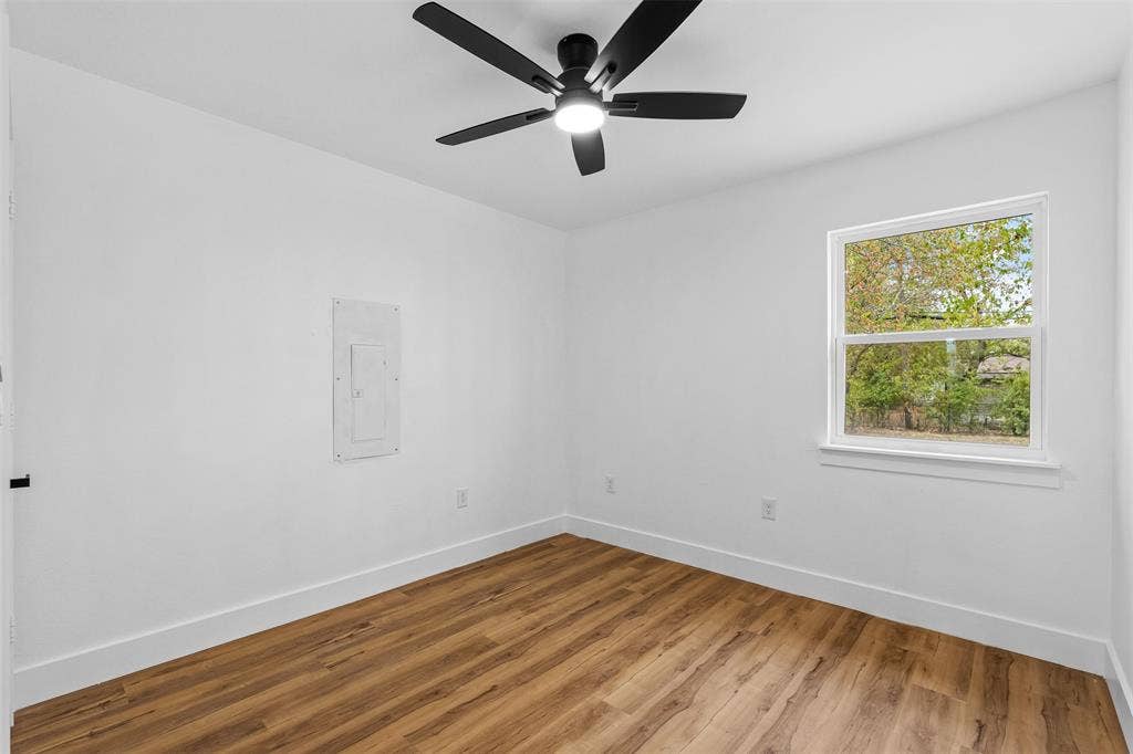 565 alcorn Avenue, Dallas, TX 75217 Bright room featuring wood-finish flooring, a contemporary ceiling fan with integrated lighting, and a window with white trim