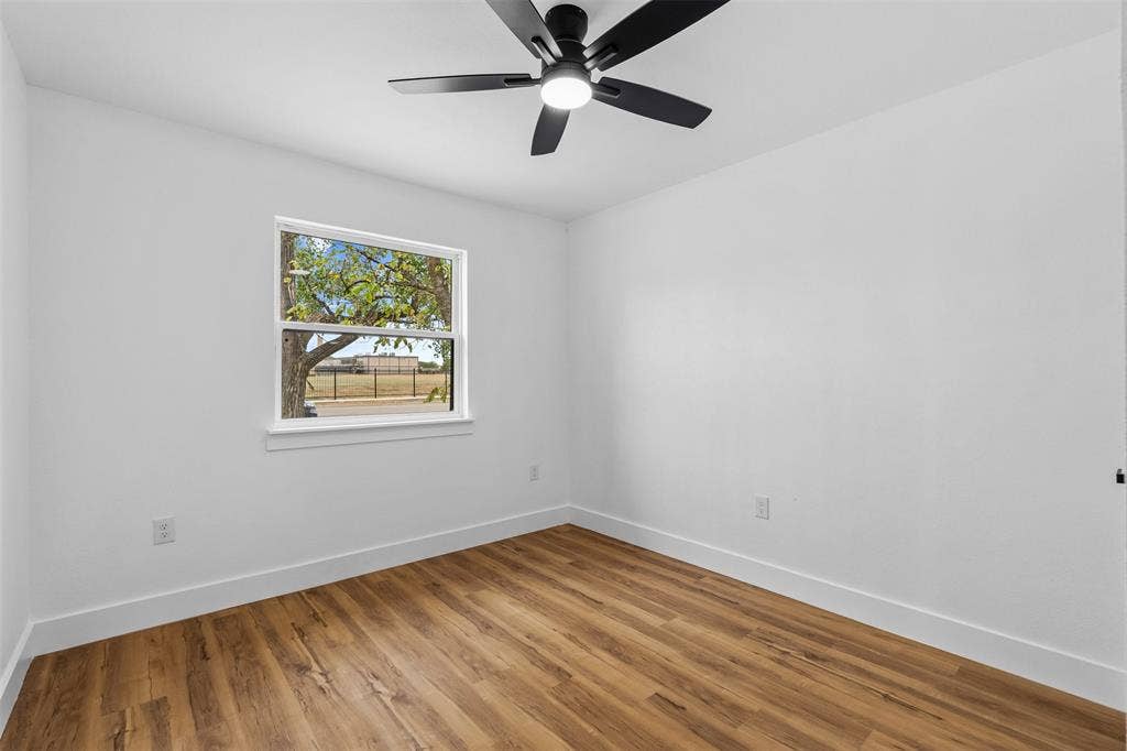 565 alcorn Avenue, Dallas, TX 75217 Wood-finish flooring, white walls, and a modern ceiling fan with integrated lighting