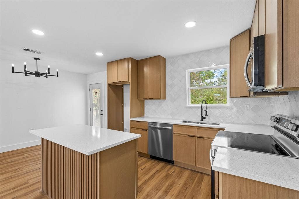 565 alcorn Avenue, Dallas, TX 75217 Kitchen featuring wood-finish cabinetry, white countertops, stainless steel appliances, and a tiled backsplash