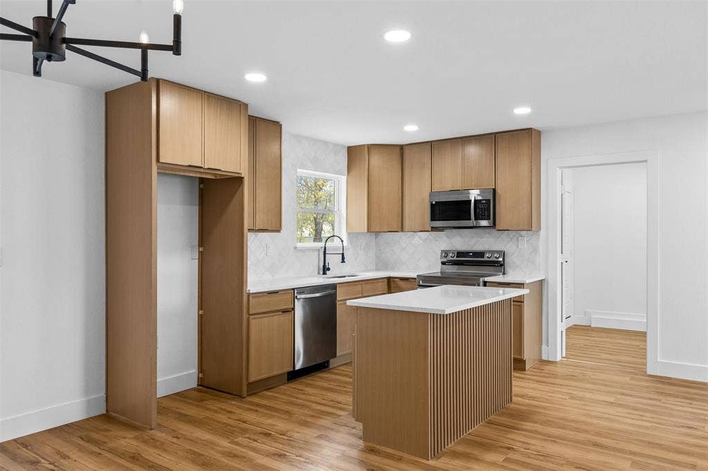 565 alcorn Avenue, Dallas, TX 75217 Modern kitchen featuring wood-finish cabinetry, stainless steel appliances, a center island with countertop, recessed lighting, and wood-finish flooring