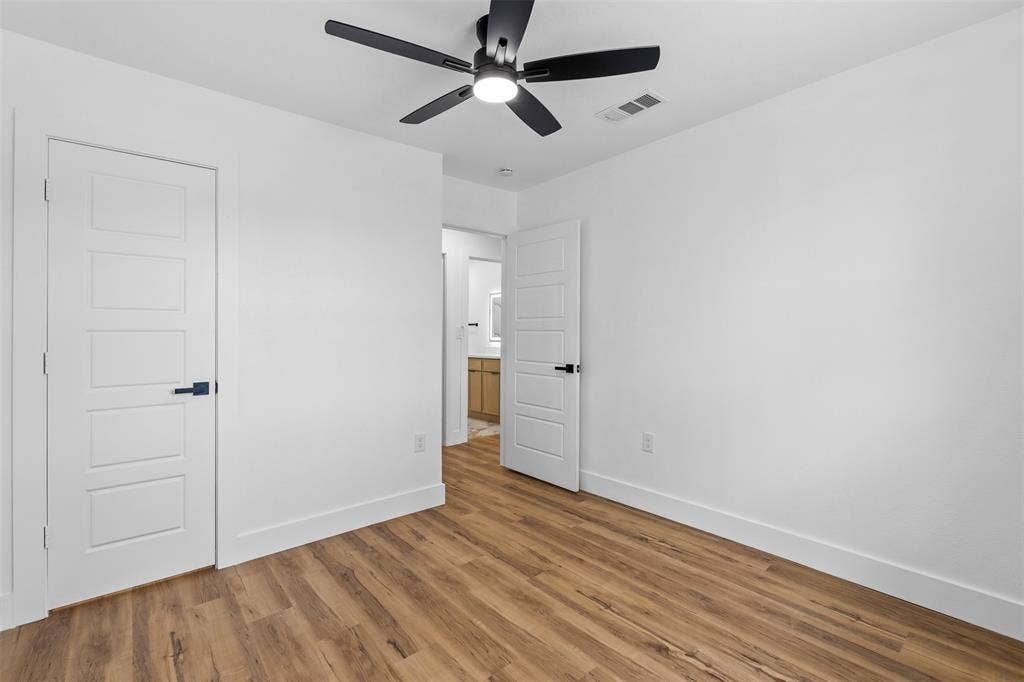 565 alcorn Avenue, Dallas, TX 75217 Wood-finish flooring, white walls, and a contemporary ceiling fan with integrated lighting