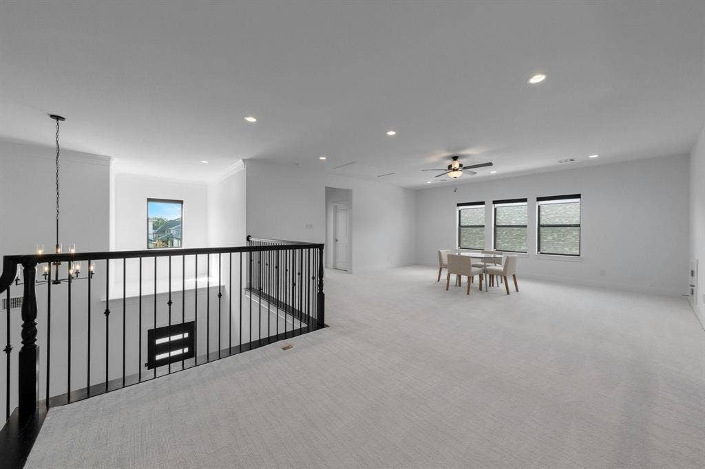 Spacious loft area featuring light-toned carpeting, recessed lighting, and a ceiling fan