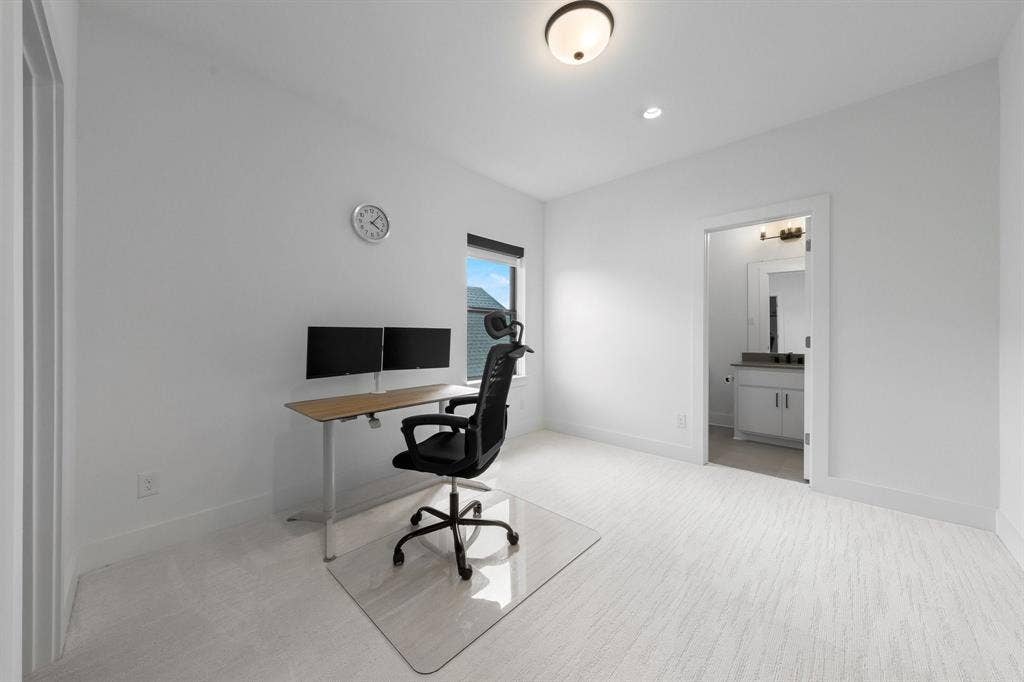 Recessed lighting, wall-mounted light fixture, and window provide illumination