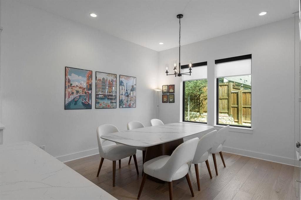 Recessed ceiling lighting, wood-finish flooring, and a modern chandelier