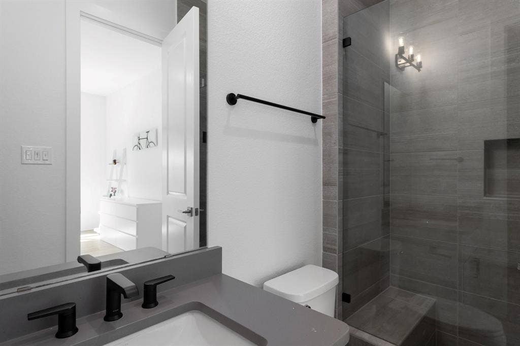 Sleek vanity with a gray countertop and matte black fixtures