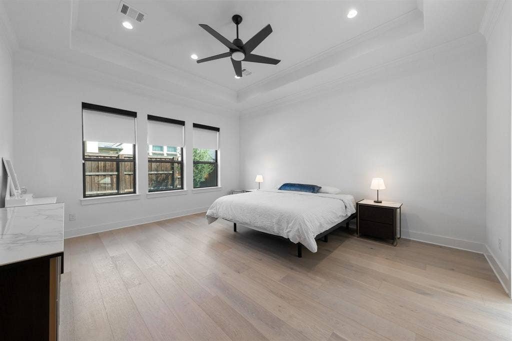 Tray ceiling with recessed lighting and a black ceiling fan