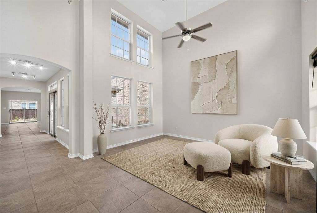 2309 Shingle Lane, Plano, TX 75074 Soaring ceilings with a ceiling fan, arched doorways, multiple large windows, and tile flooring