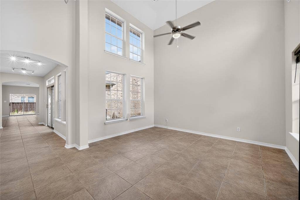 2309 Shingle Lane, Plano, TX 75074 Soaring vaulted ceiling, ceiling fan, large format tile flooring, multiple windows, and recessed lighting