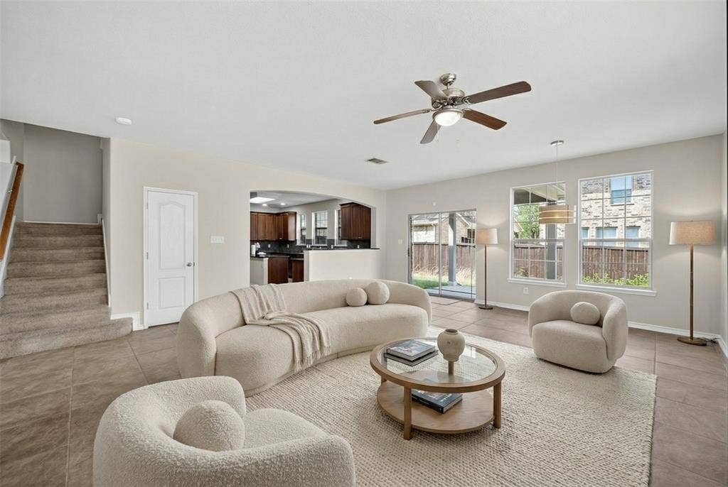 2309 Shingle Lane, Plano, TX 75074 Tile flooring, overhead ceiling fan, multiple windows, sliding glass door, and staircase with wood handrail