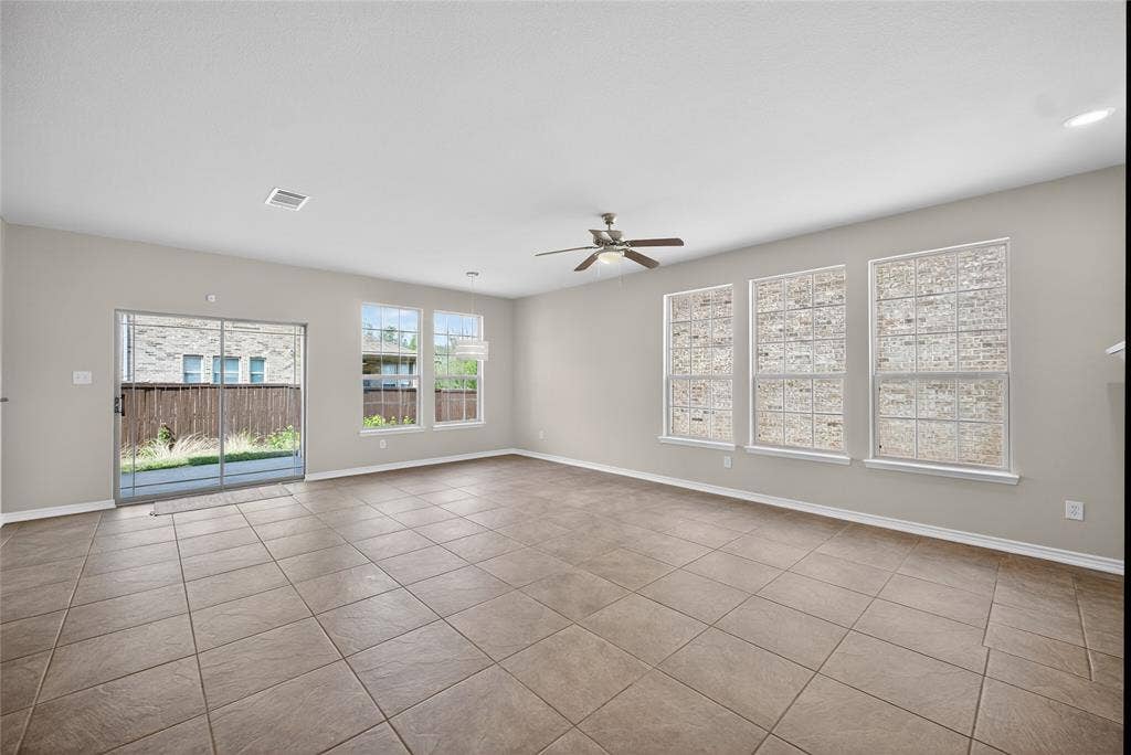 2309 Shingle Lane, Plano, TX 75074 Spacious living area featuring neutral wall tones, tile flooring, and multiple windows