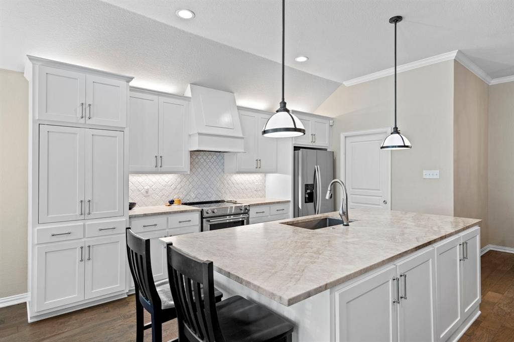 11701 Cambria Court, Fort Worth, TX 76008 Bright kitchen featuring white shaker-style cabinetry, a large kitchen island with integrated sink, stainless steel appliances, and recessed lighting