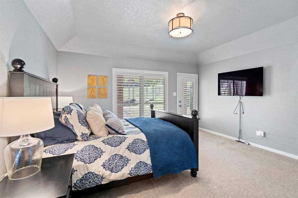 11701 Cambria Court, Fort Worth, TX 76008 Vaulted ceiling, ceiling-mounted light fixture, carpeted flooring, sliding glass door, and a single-panel door with louvered shutters