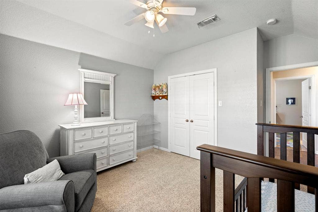 11701 Cambria Court, Fort Worth, TX 76008 Vaulted ceiling, ceiling fan, neutral carpet, wood-finish railing, and white double-door closet
