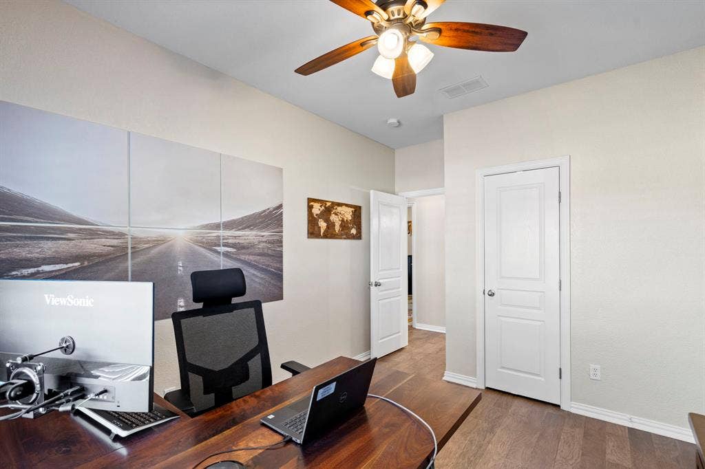 11701 Cambria Court, Fort Worth, TX 76008 Wood-finish flooring, two paneled doors, and a ceiling fan with integrated lighting