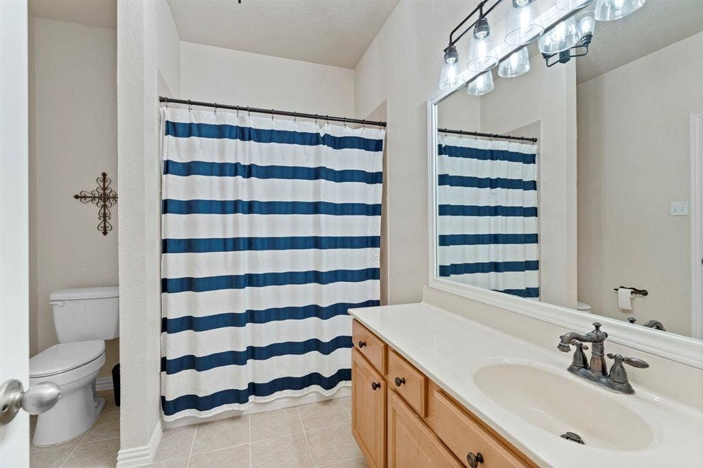11701 Cambria Court, Fort Worth, TX 76008 Spacious bathroom with a single vanity, integrated sink, and an expansive wall-mounted mirror
