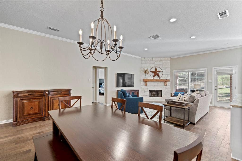 11701 Cambria Court, Fort Worth, TX 76008 Wood-finish flooring throughout, a chandelier light fixture, and crown molding