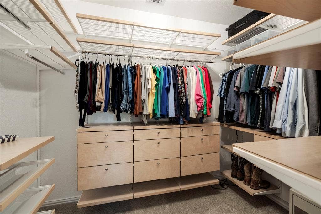 11701 Cambria Court, Fort Worth, TX 76008 Customizable closet system with wood-finish shelving, built-in drawer storage, and ample hanging space