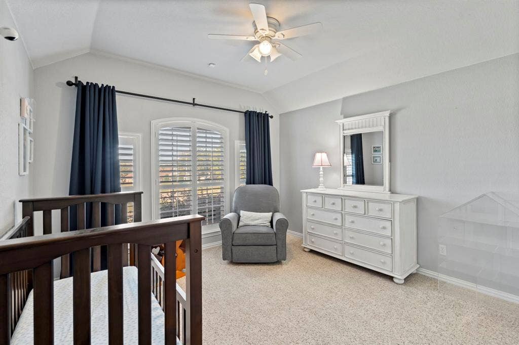 11701 Cambria Court, Fort Worth, TX 76008 Vaulted ceiling with a ceiling fan, arched window with plantation shutters, wall-to-wall carpeting, and crown molding