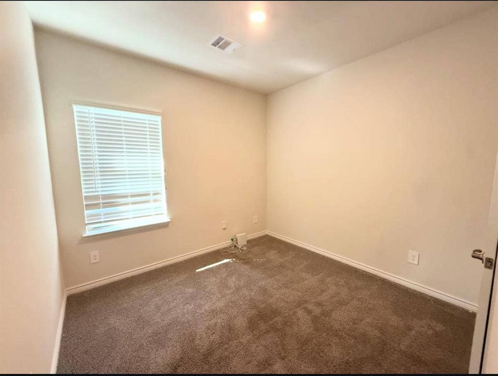 Neutral-toned room featuring neutral carpeting, a single-window configuration with horizontal blinds, and a recessed ceiling light
