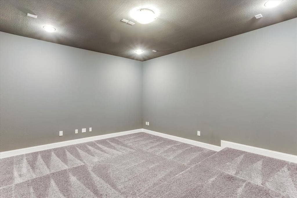 Recessed lighting, flush mount ceiling fixture, gray wall finish, white trim, and gray patterned carpeting