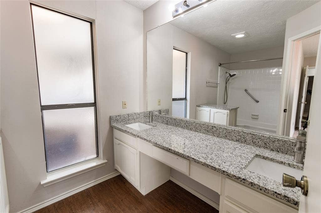 1328 Colmar Drive, Plano, TX 75023 Double vanity with integral sinks, granite-style countertop, and wood-finish flooring