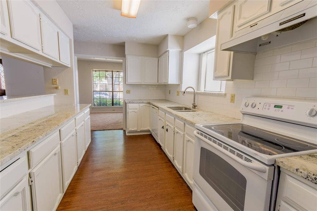 1328 Colmar Drive, Plano, TX 75023 Kitchen featuring white cabinetry, granite countertops, wood-finish flooring, subway tile backsplash, and a built-in electric range
