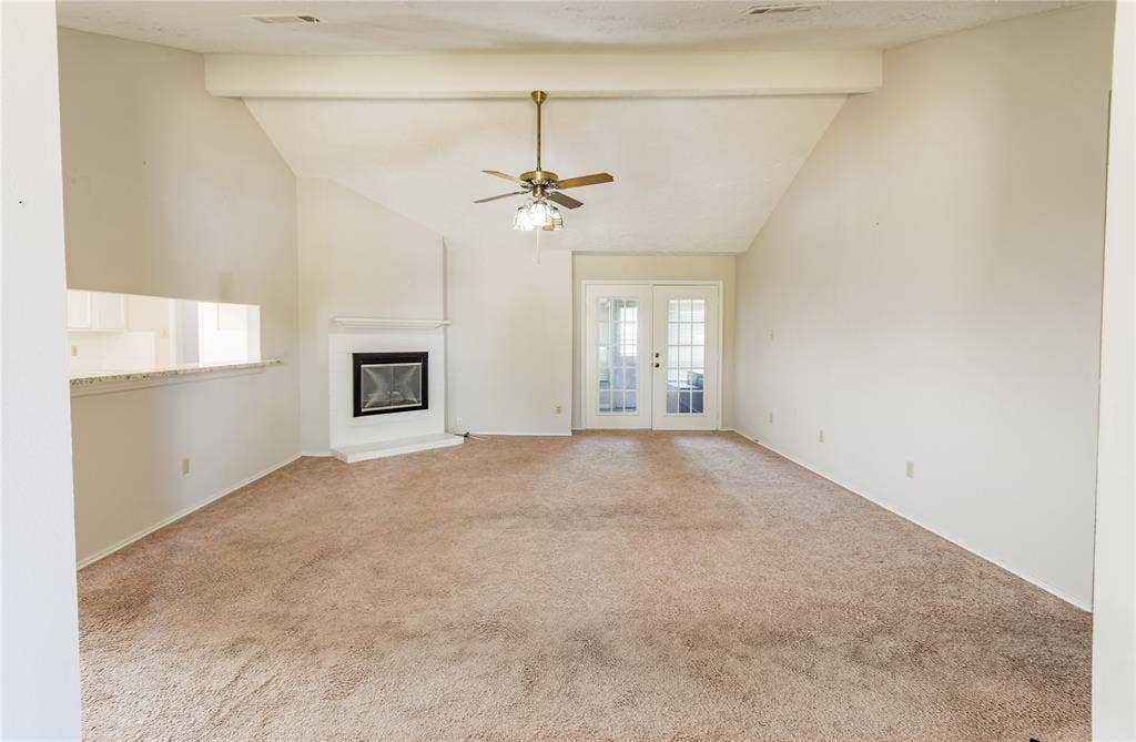 1328 Colmar Drive, Plano, TX 75023 Vaulted ceilings with exposed beam, ceiling fan, corner fireplace, and French doors