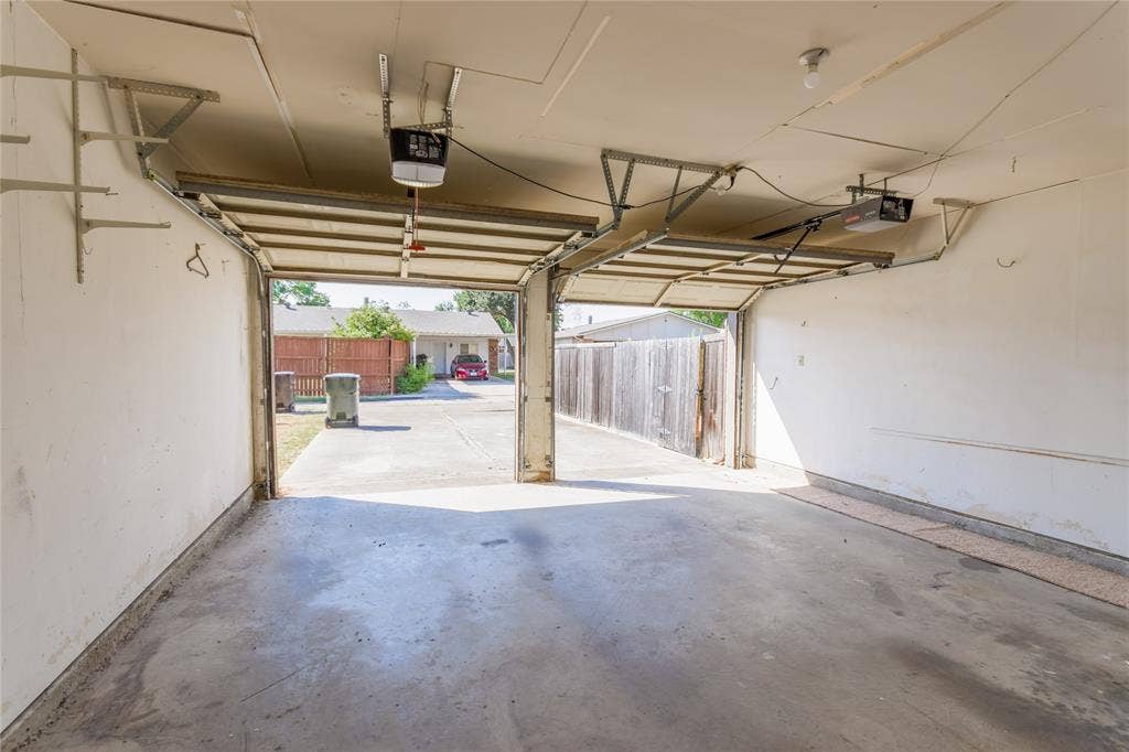 1328 Colmar Drive, Plano, TX 75023 Two-car garage with concrete flooring and exposed ceiling joists