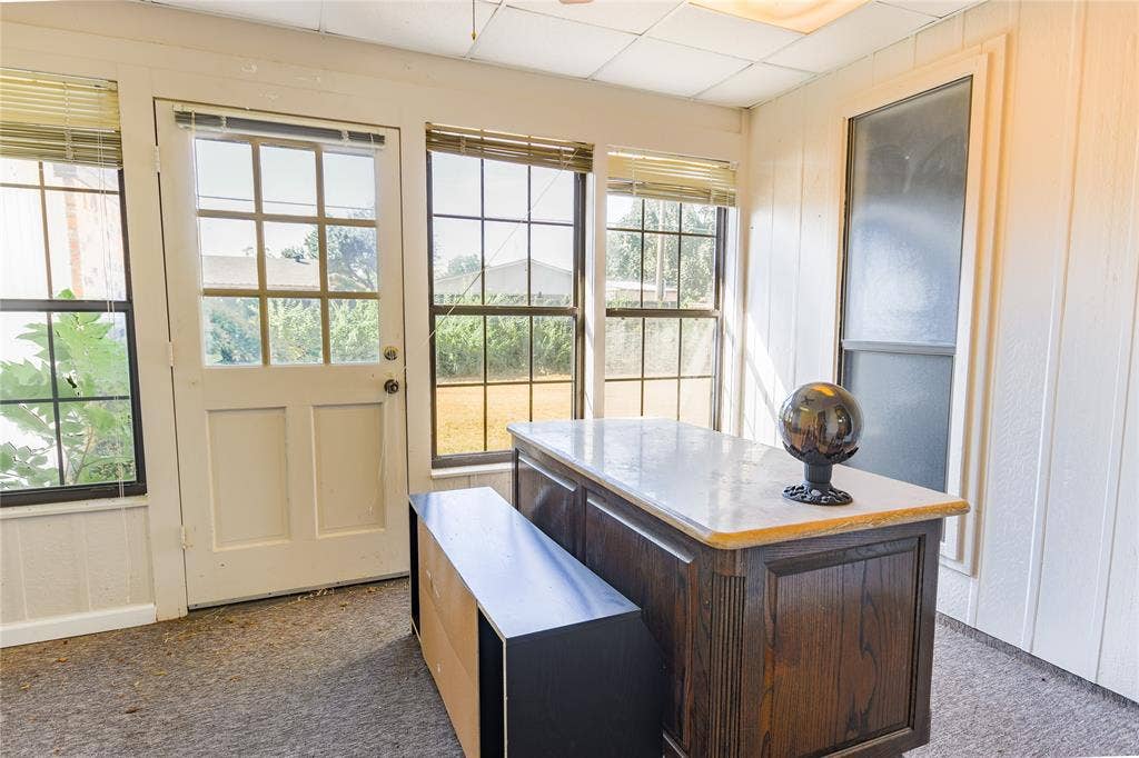 1328 Colmar Drive, Plano, TX 75023 Sunroom with a paneled exterior door, multiple grid-pattern windows, and vertical plank wall paneling