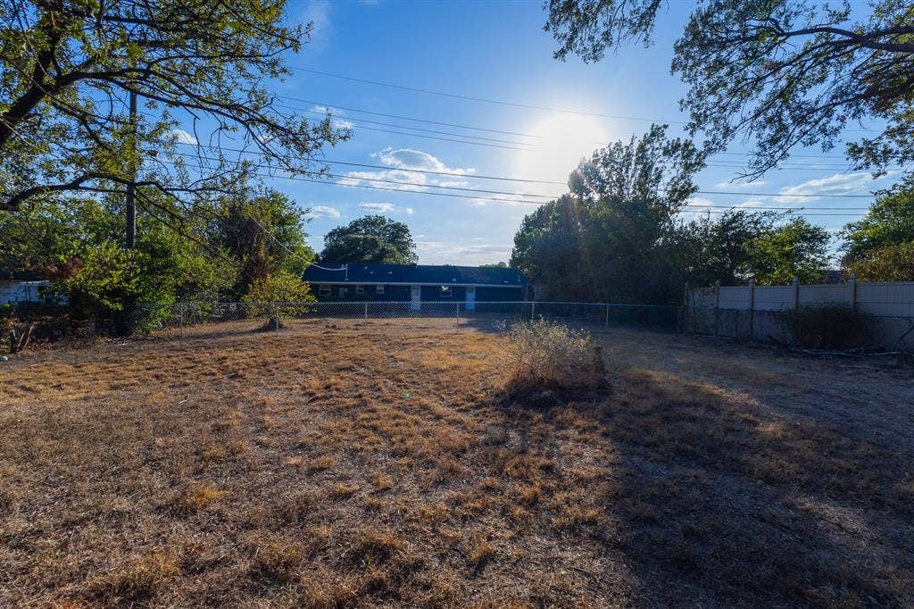 1122 Timberline Street, Bellmead, TX 76705 Expansive lot featuring mature trees and a chain-link fence
