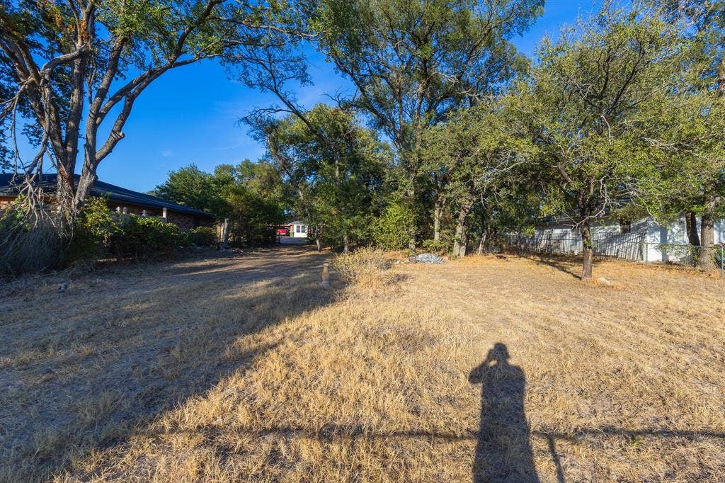 1122 Timberline Street, Bellmead, TX 76705 Expansive outdoor space featuring mature trees and a sloped terrain