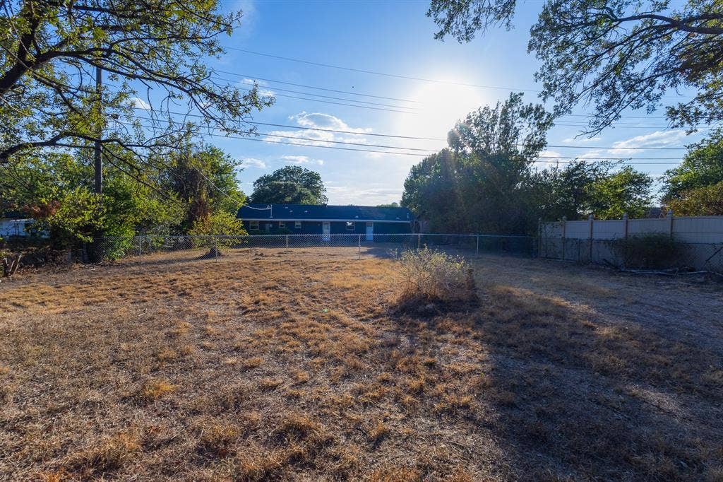 1122 Timberline Street, Bellmead, TX 76705 Expansive rear yard with a chain-link fence and a concrete wall perimeter