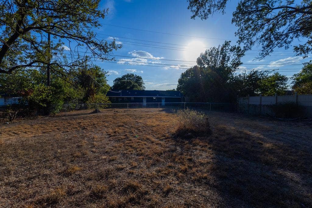 1122 Timberline Street, Bellmead, TX 76705 Expansive backyard with a chain-link fence and mature perimeter trees