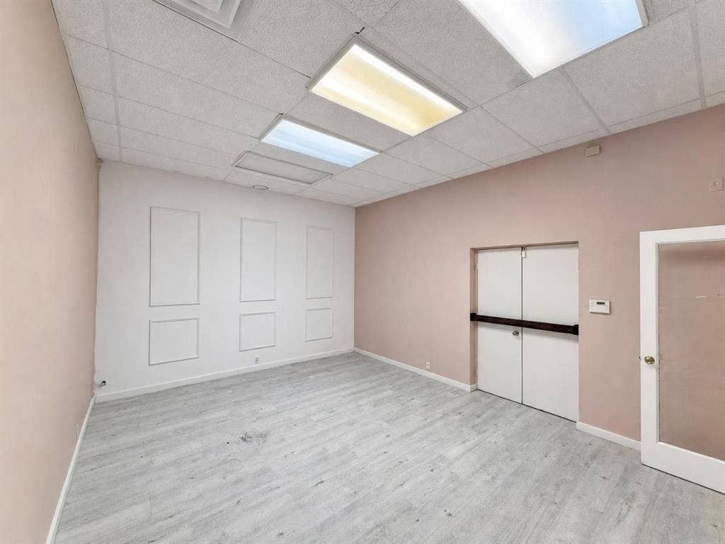 607 Cedar Street, Cedar Hill, TX 75104 Recessed ceiling with integrated lighting, decorative wall paneling, wood-finish flooring, and a glass-paneled door