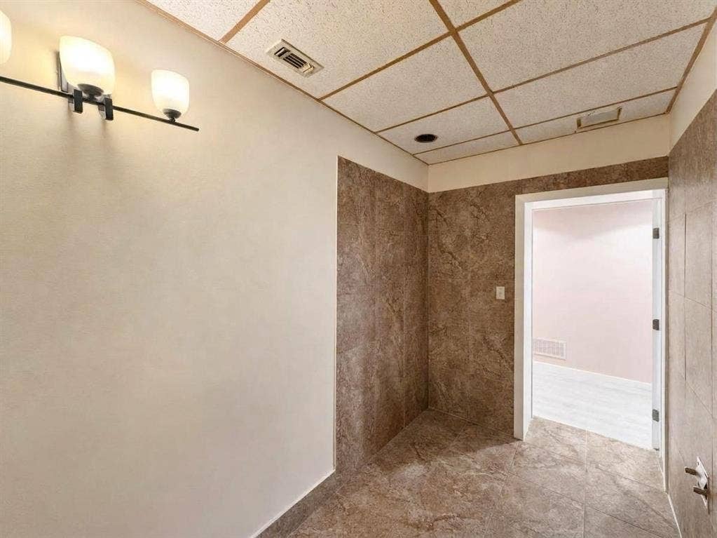 607 Cedar Street, Cedar Hill, TX 75104 Recessed ceiling lighting, flush-mounted light fixture, full tile flooring, partial wall tiling, and a drop ceiling