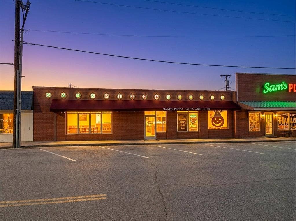 607 Cedar Street, Cedar Hill, TX 75104 Brick storefront with multiple large display windows, a retractable awning, and exterior lighting