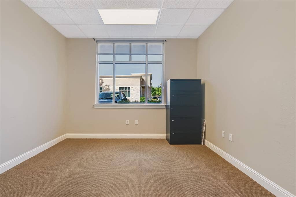 3900 S Stonebridge Drive, #203, McKinney, TX 75070 Wall-to-wall carpeting, neutral wall finishes, drop ceiling, and a large multi-pane window
