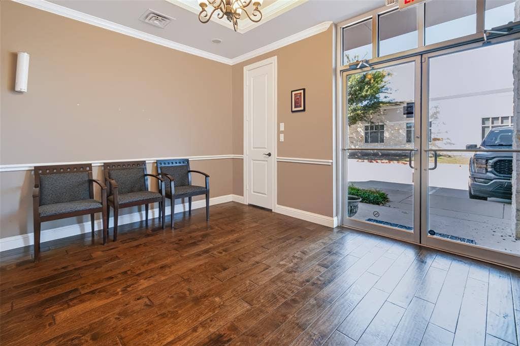 3900 S Stonebridge Drive, #203, McKinney, TX 75070 Wood-finish flooring, crown molding, chair rail, and a decorative ceiling fixture
