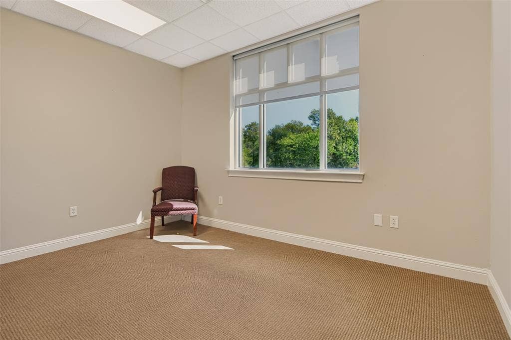 3900 S Stonebridge Drive, #203, McKinney, TX 75070 Carpeted flooring with neutral wall paint, white trim, and a large window
