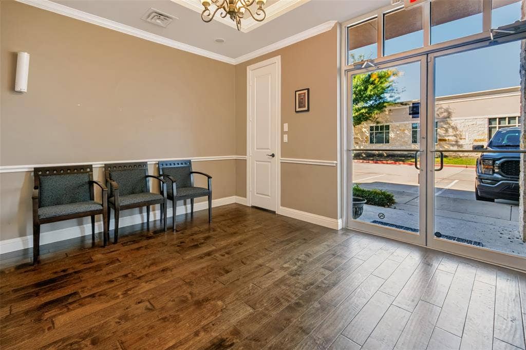 3900 S Stonebridge Drive, #203, McKinney, TX 75070 Wood-finish flooring, crown molding, chair rail molding, and a chandelier with decorative ceiling medallion