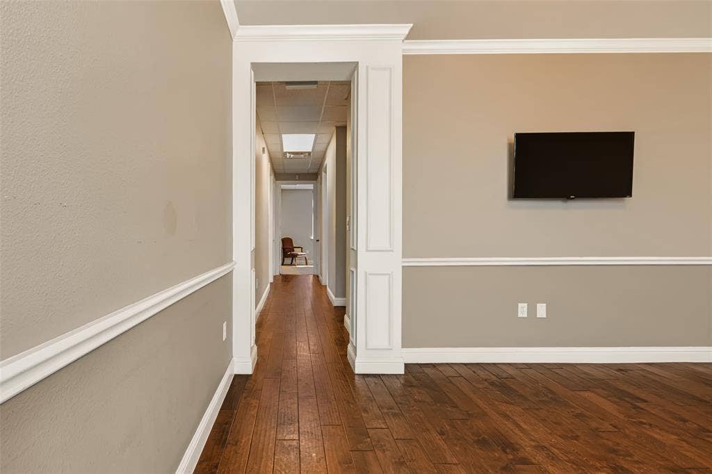 3900 S Stonebridge Drive, #203, McKinney, TX 75070 Wood-finish flooring throughout, featuring decorative crown molding and chair rail