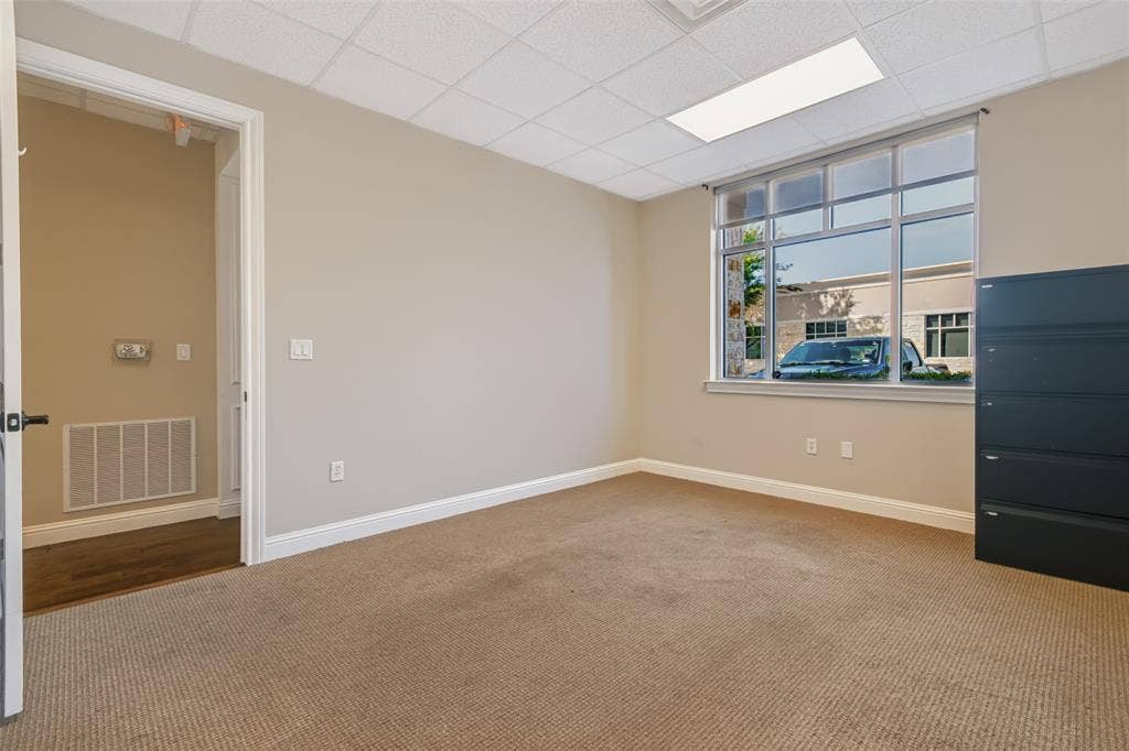 3900 S Stonebridge Drive, #203, McKinney, TX 75070 Carpeted room with a drop ceiling, transom window, and a white trim package