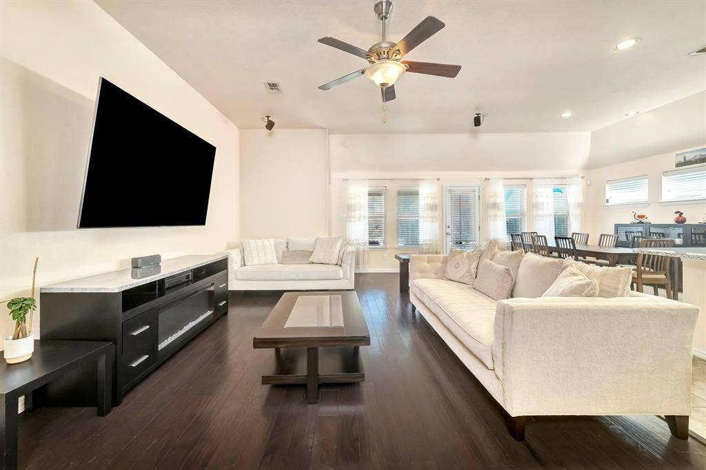 Vaulted ceilings, wood-finish flooring, recessed lighting, and a ceiling fan with integrated light fixture