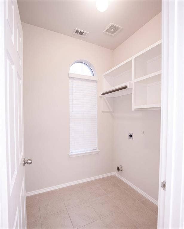 11398 Seguin Drive, Frisco, TX 75035 Arched window, tile flooring, built-in shelving, clothes rod, and an overhead light fixture